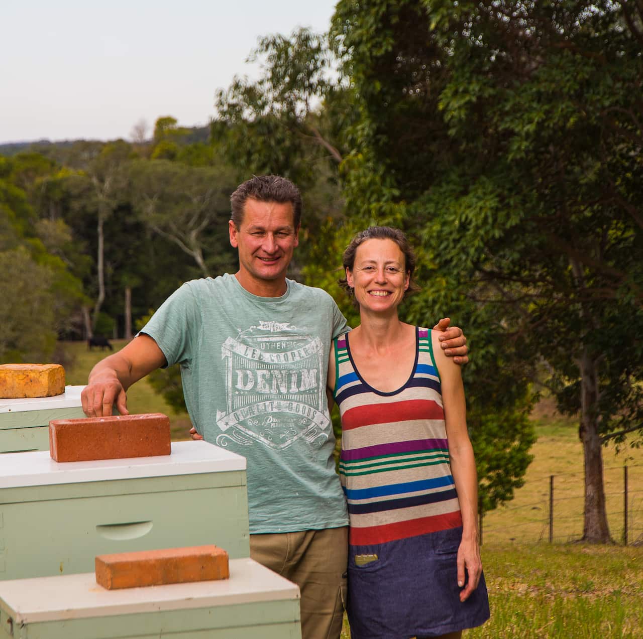 Owners of Amber Drop Honey, Ana Martin and Sven Stephan, on their farm next to a few of their beloved hives. 