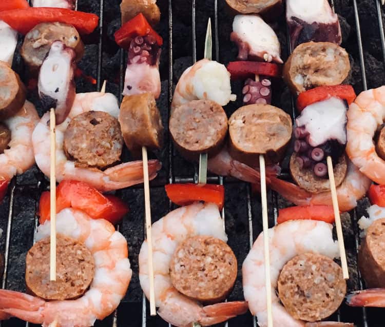 Pachamanca are behind the grill cooking up Anticuchos (marinated meat skewers)