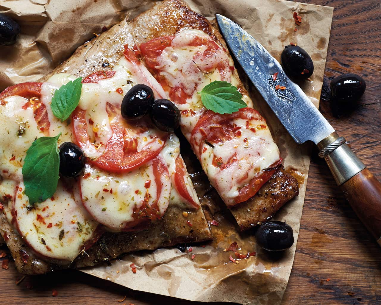 Barbecued matambre 'pizza' with provolone, tomato, olives and oregano
