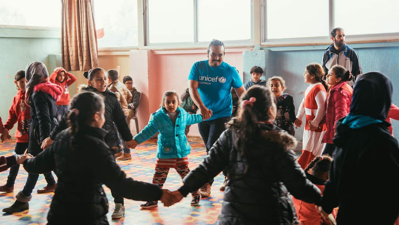 Adam Liaw, centre, dancing with some of the children in the Zaatari camp.