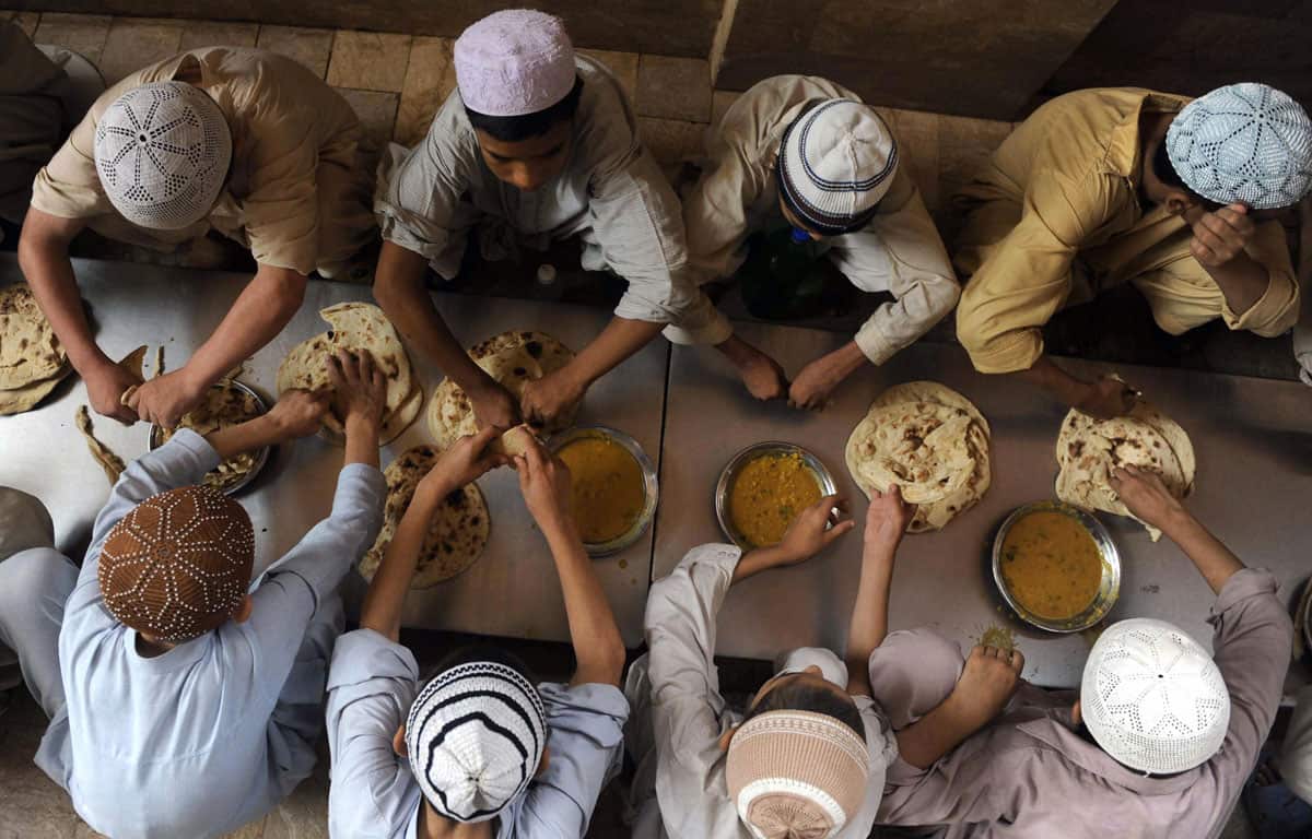 students eat a meal at a seminary in Karachi,  Pakistan