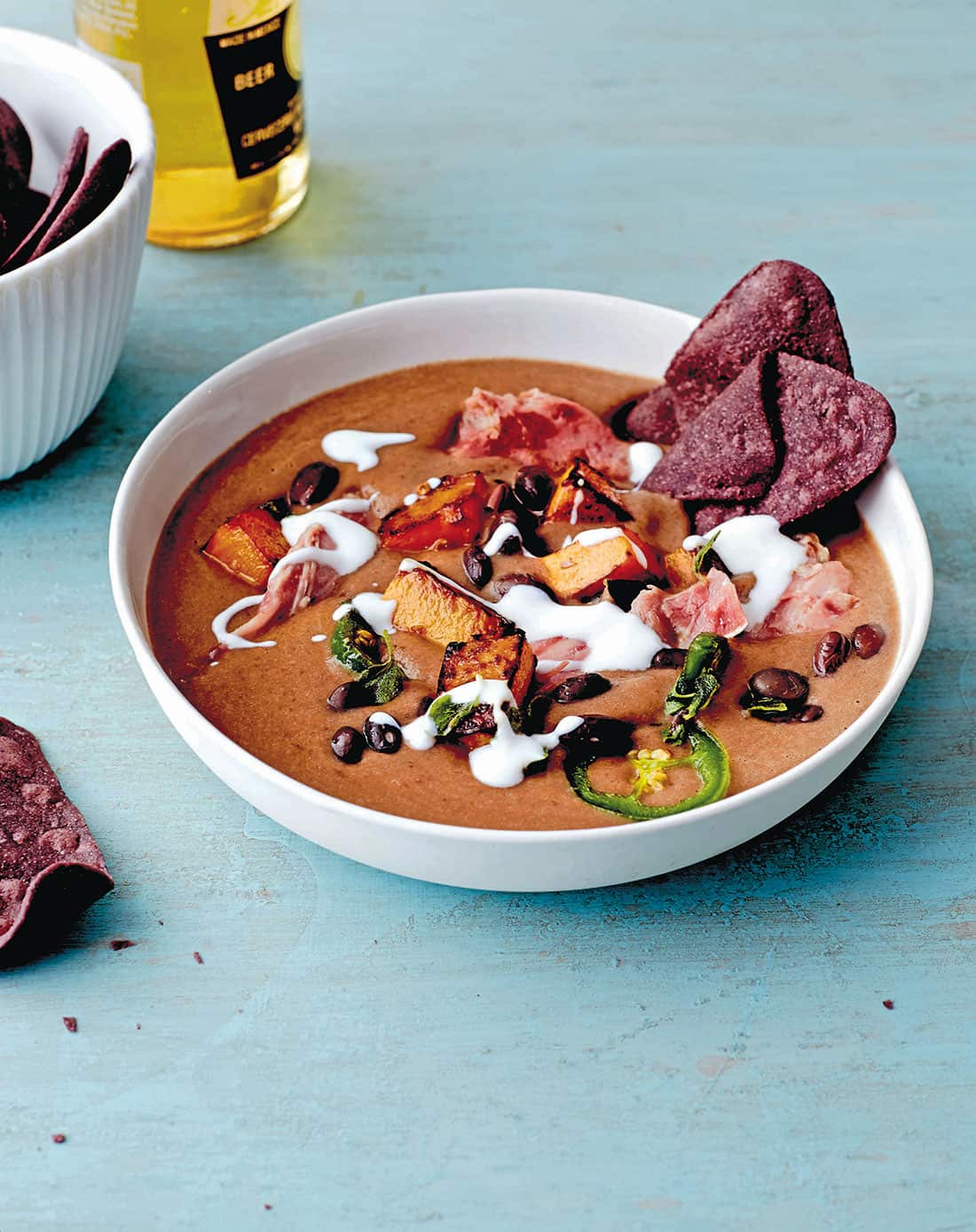Black and blue corn tortilla soup with bacon and pumpkin