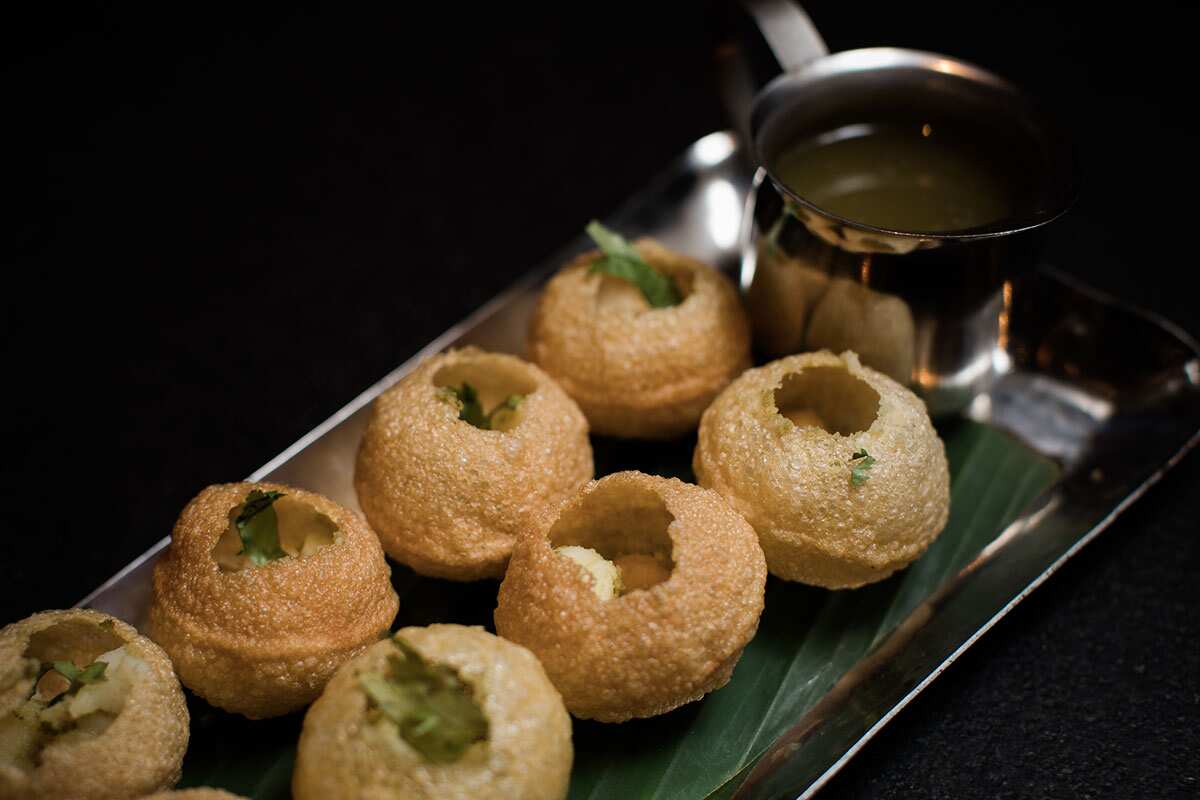Pani puri are puffed up pastries stuffed with potatoes, chickpeas, coriander and mint.