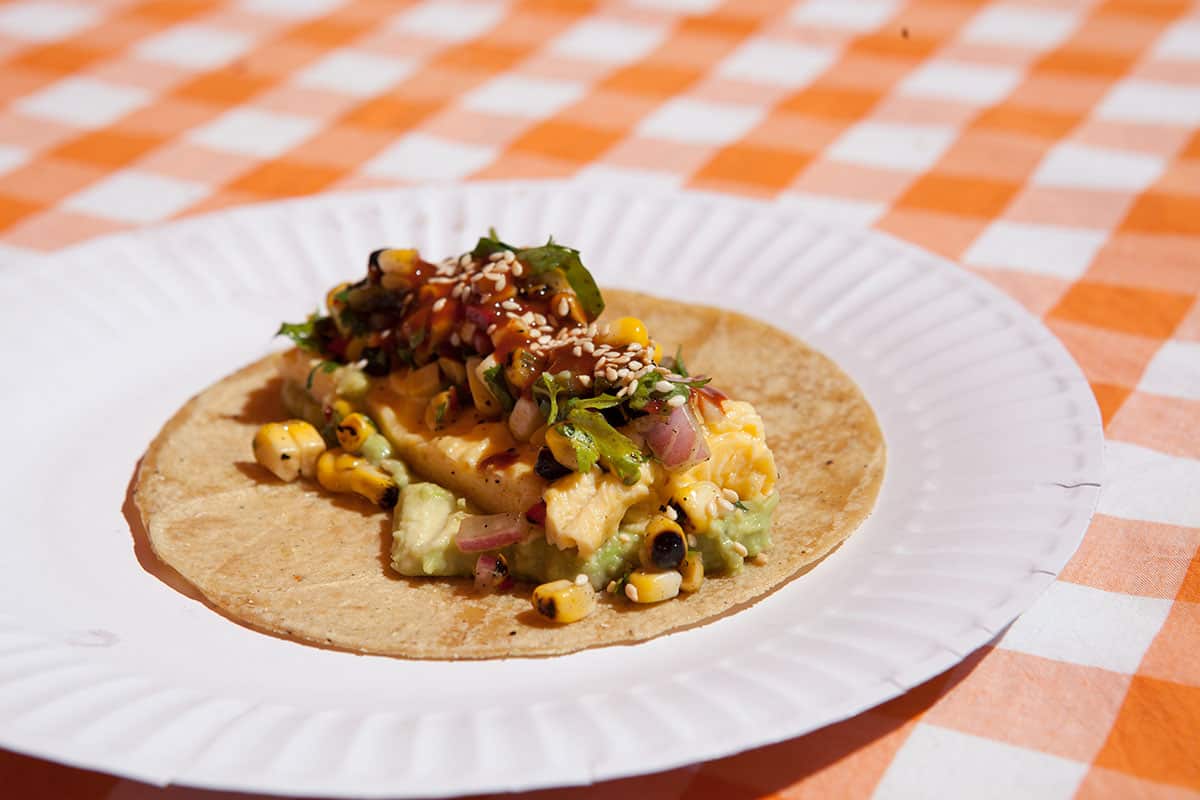 Breakfast tacos with avocado, scrambled eggs, corn salsa and hot sauce