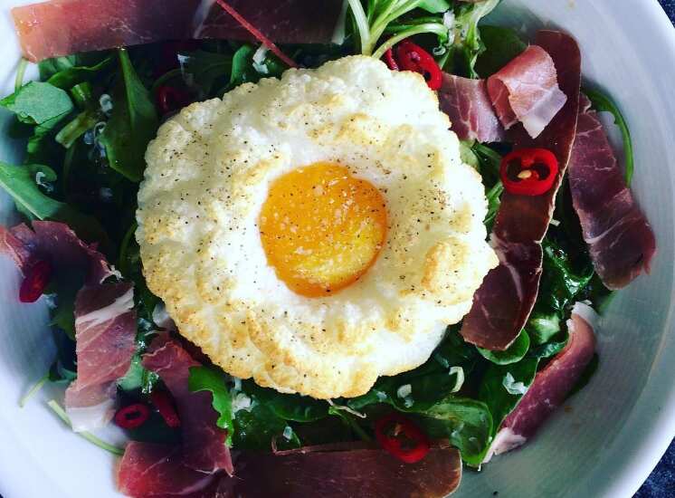 A salad topped with a cloud egg.