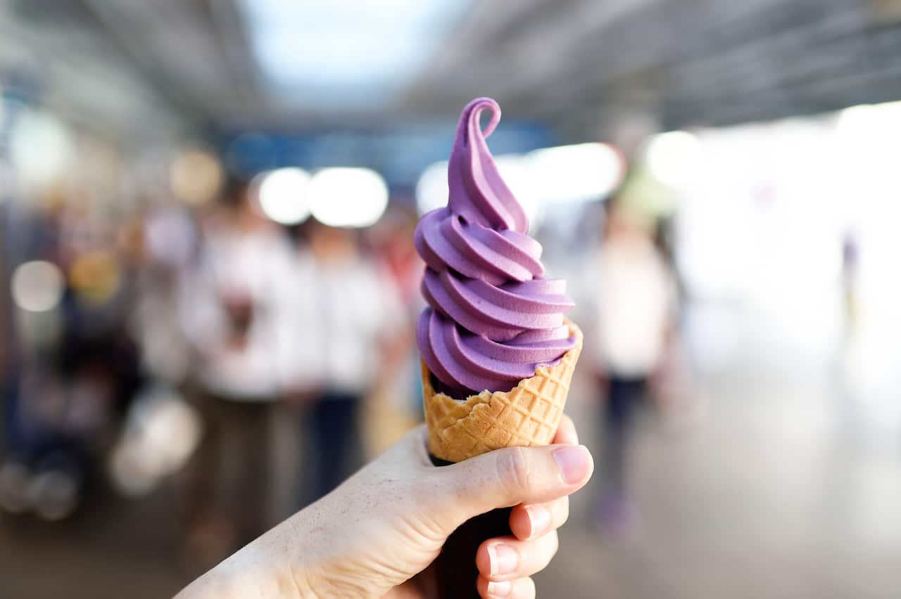 hand holding a yam soft serve ice cream cone outdoors