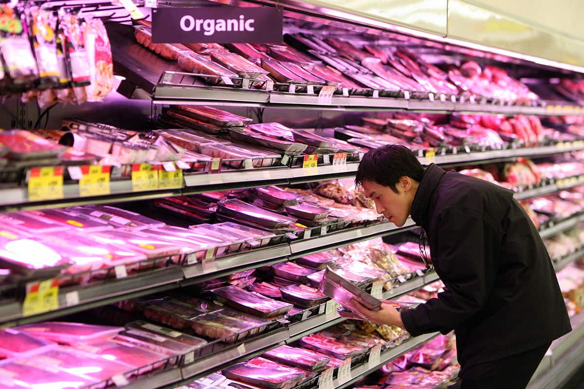 A customer selects meat products at a Woolworths supermarket