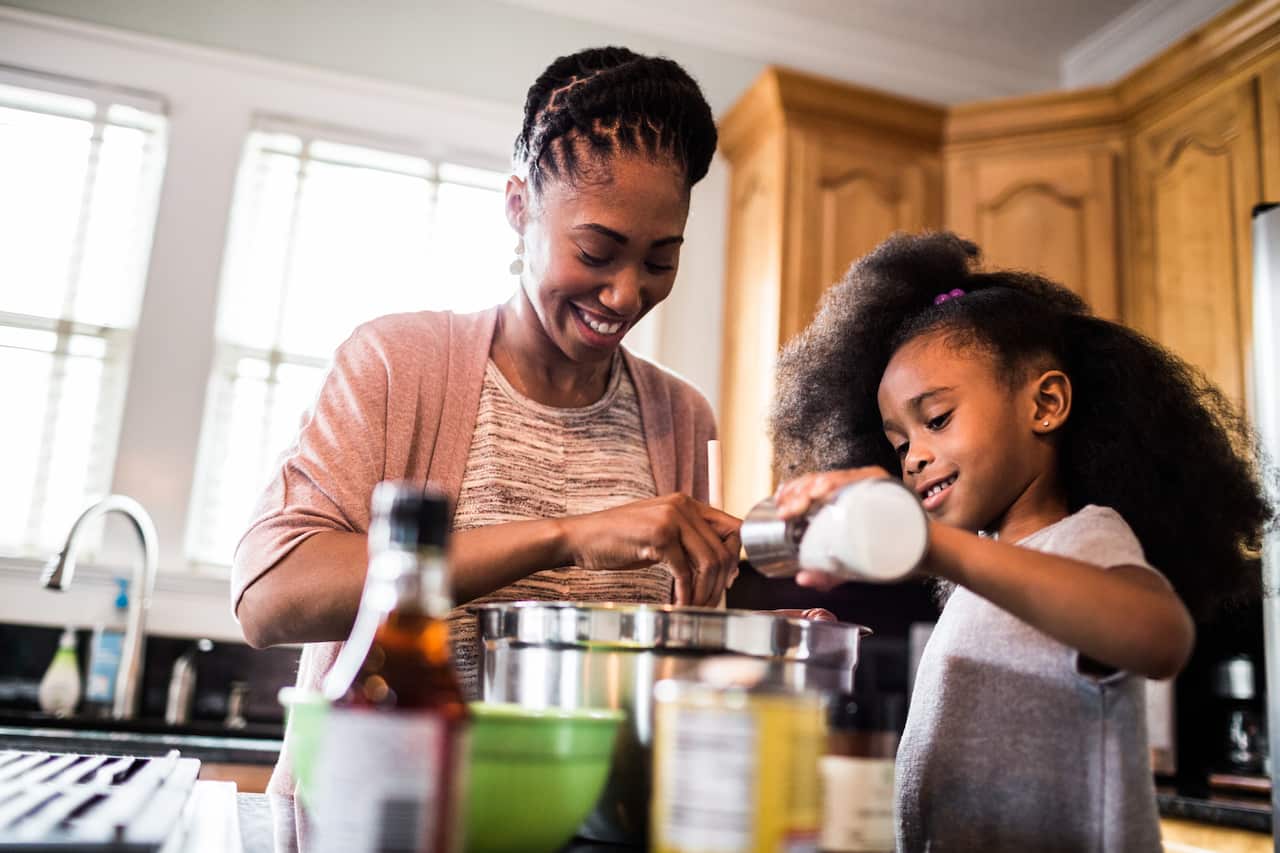 mother and daughter cooking at home - children cooking with parent