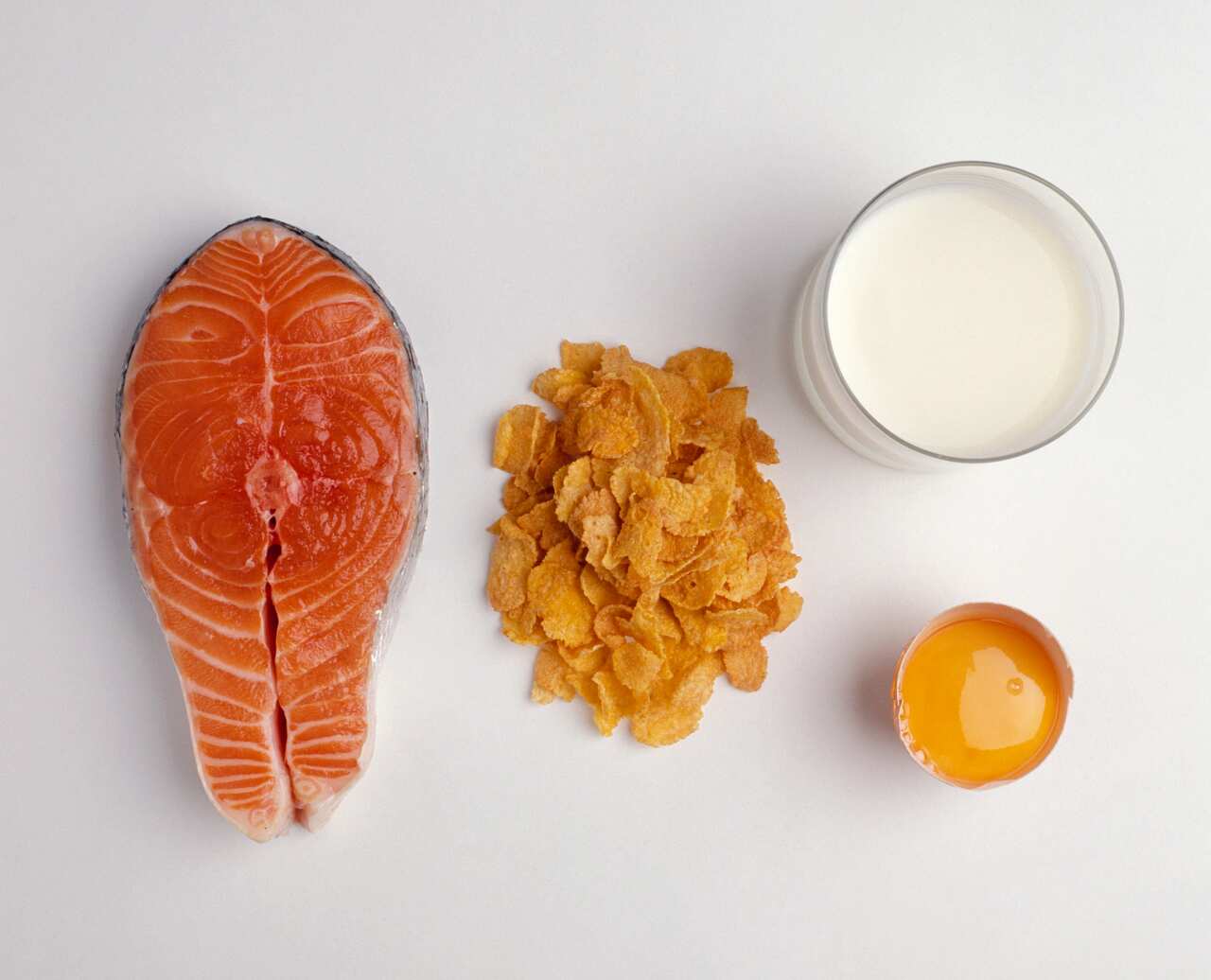 Salmon steak, fortified cereals (cornflakes), glass of milk and egg yolk, all sources of Vitamin D