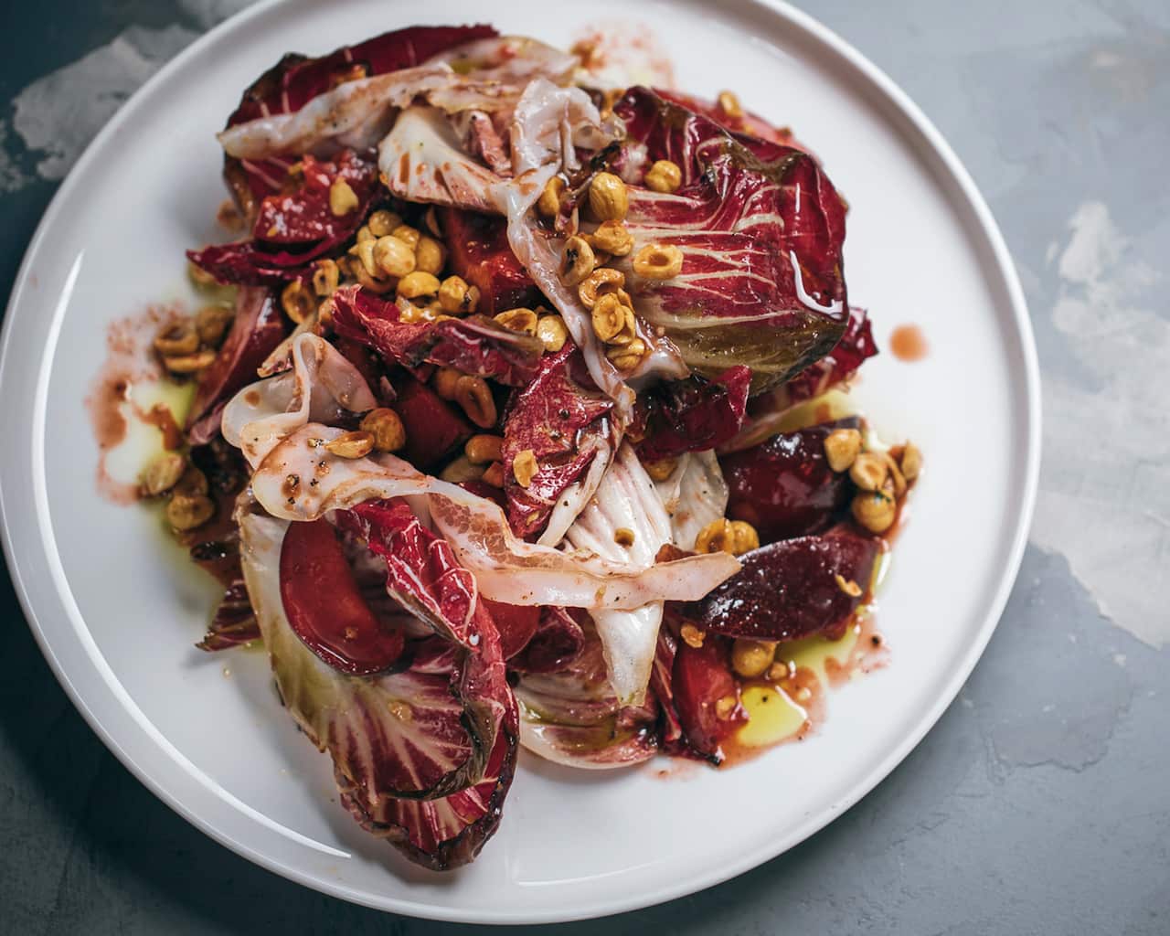 Grilled radicchio salad with plums, hazelnuts and guanciale