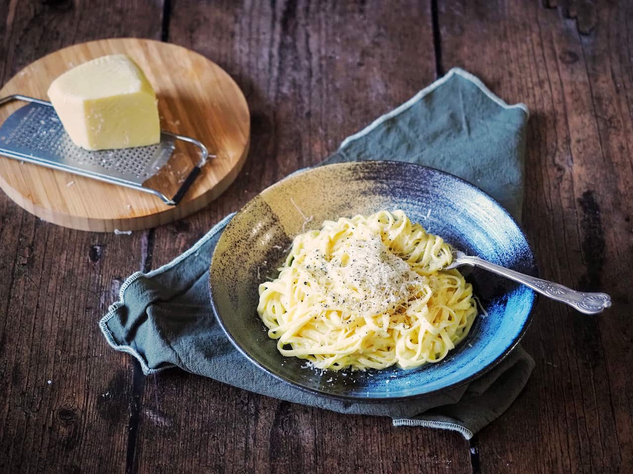 Cheesy chitarra pasta adorned simply with black pepper