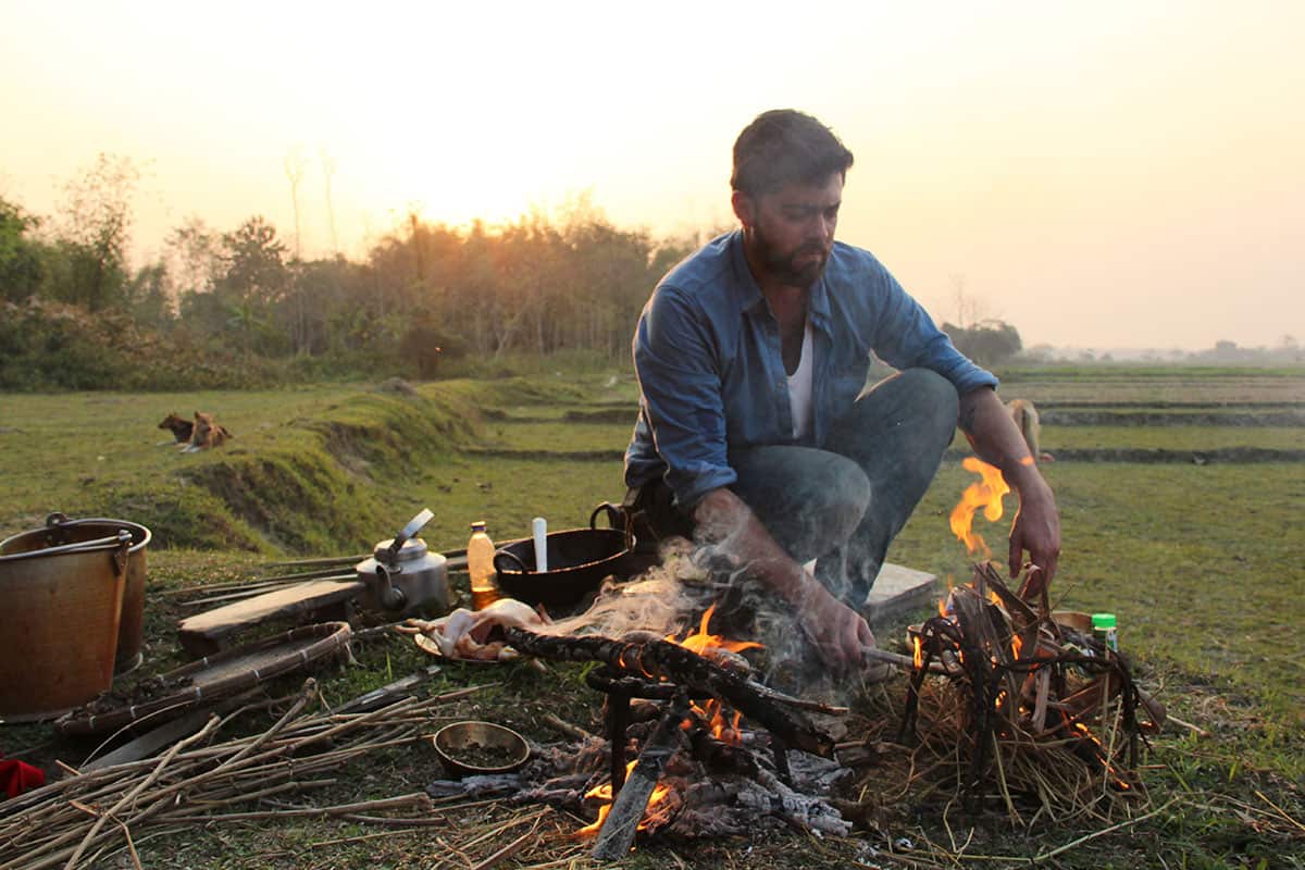 Pablo Naranjo Agular cooks during a visit to the Bodo tribe