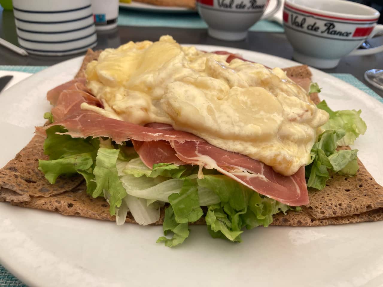 Feast your eyes on this galette topped with green salad, potato, cream, raclette cheese and country ham.