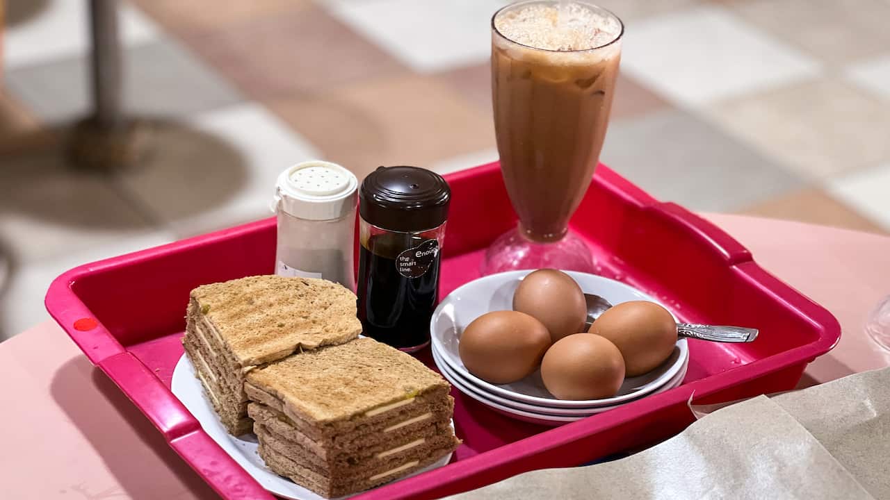 Kaya toast breakfast set with eggs and iced teh in a Singaporean hawker