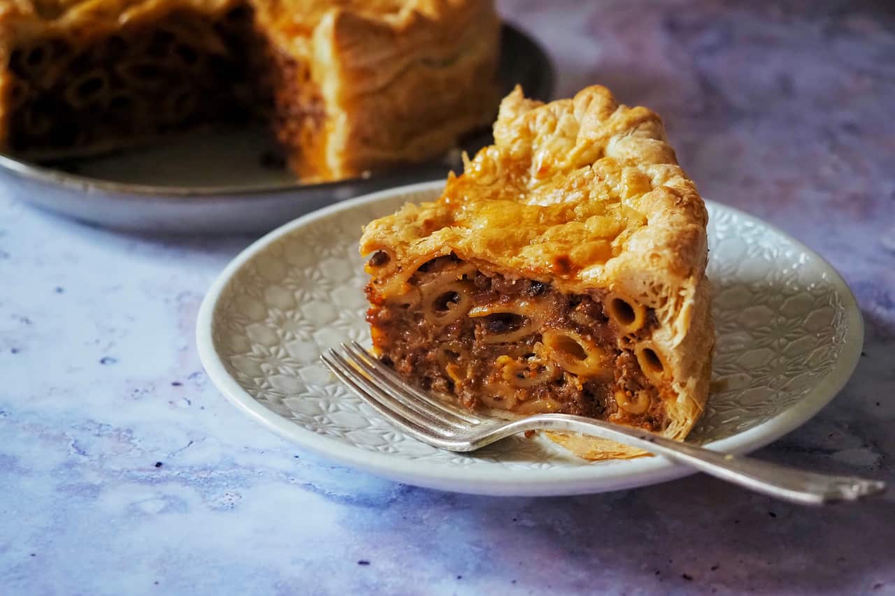 A slice of timpana on a white plate