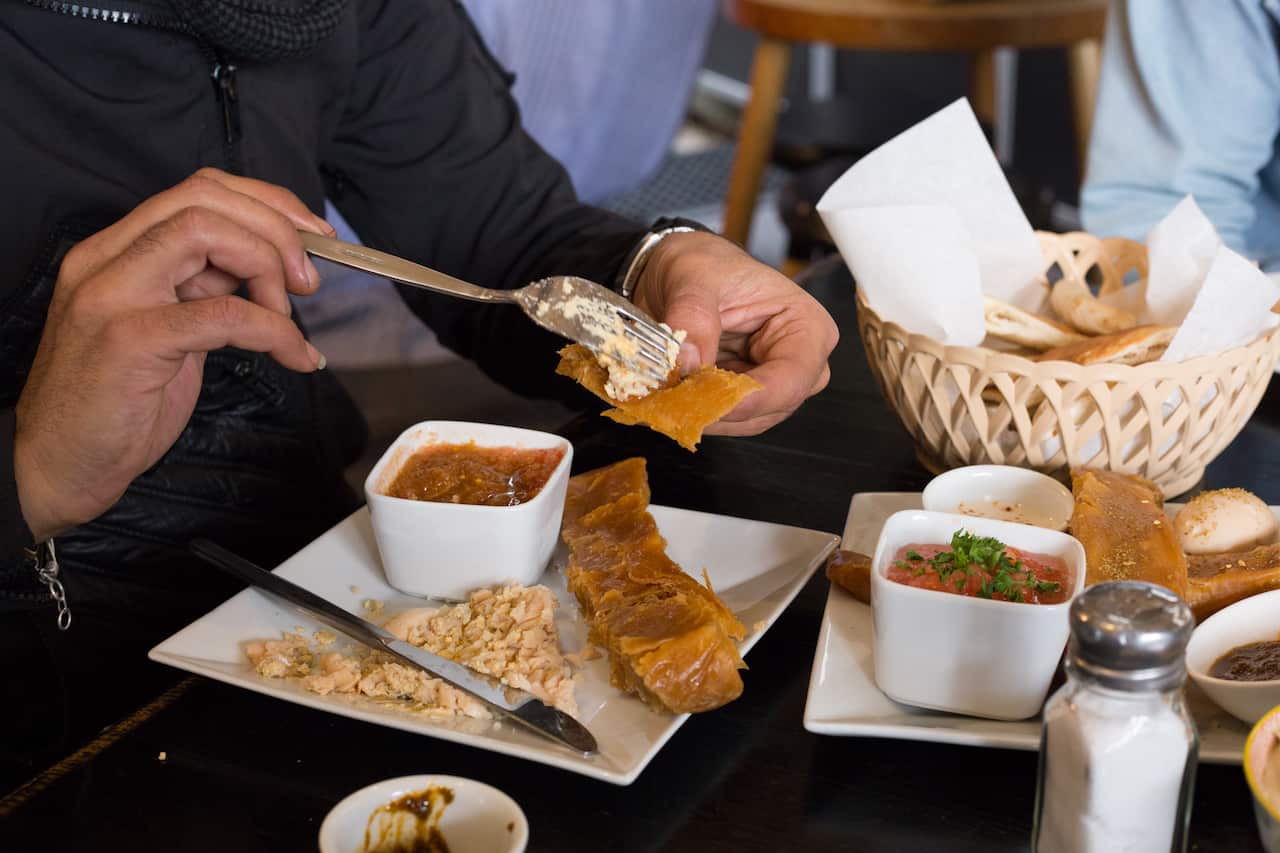 Gili Nachum demonstrating how to eat the jachnun.