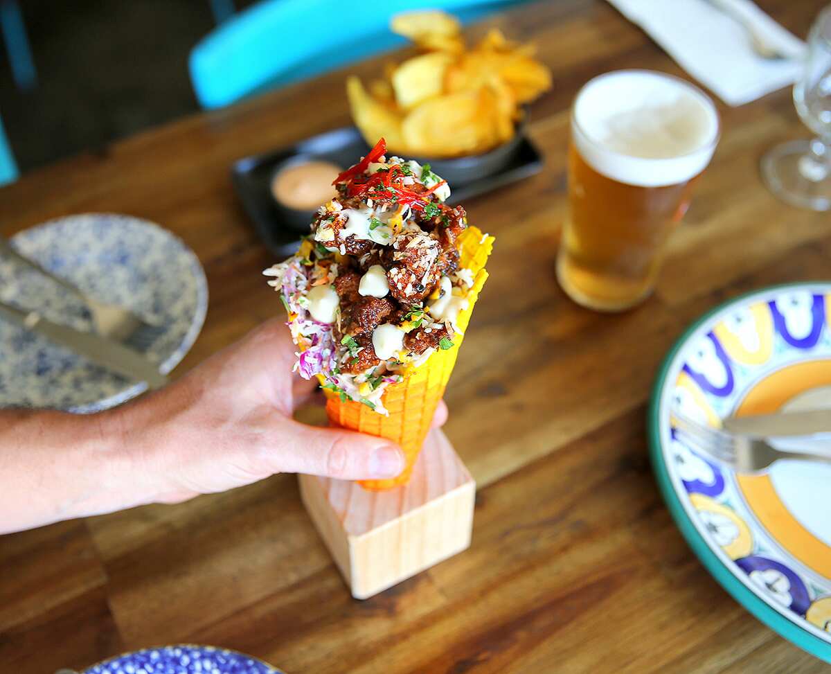 Jerk chicken is piled into waffle cones with candied chilli, charred corn, toasted coconut and lime mayo.