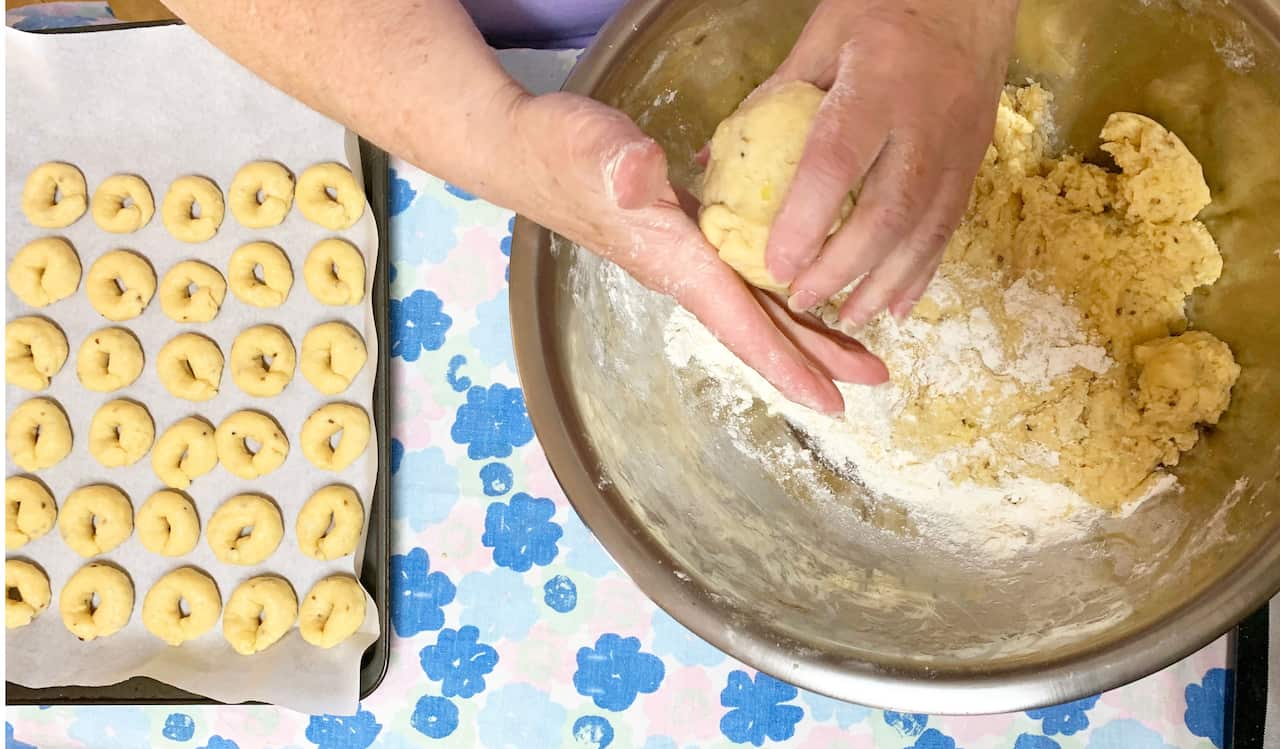 Tata Emmie rolling out rosquitos atop the ironing board, where she likes to work.