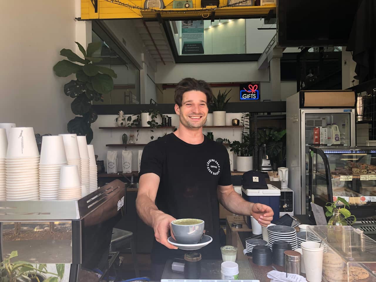 Loading Dock Coffee owner, Tom Sharpe, serves a freshly brewed broccoli sprout latte. 