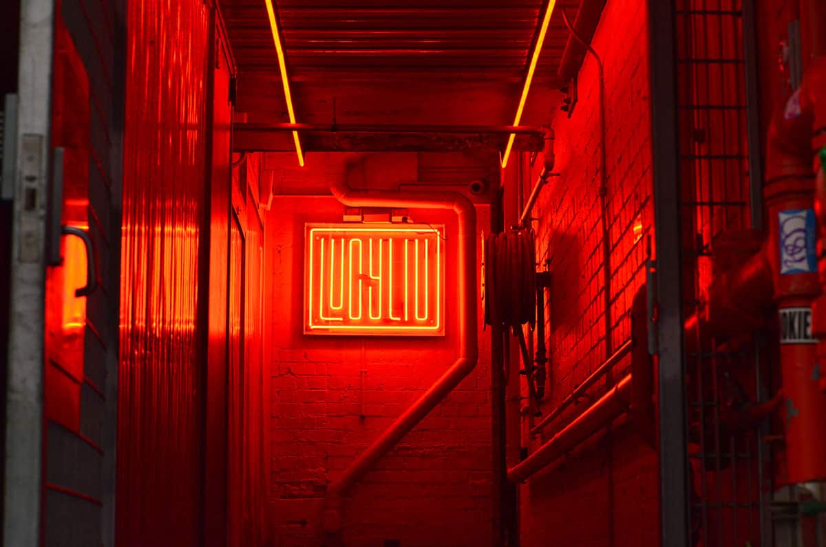 Follow a cobblestone road to a large red neon-lit sign.