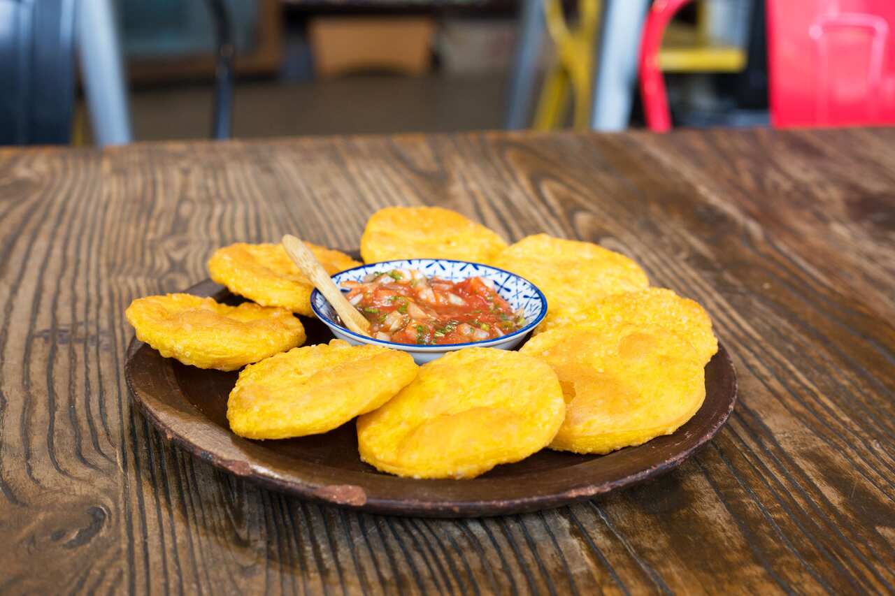 Sopaipillas served with pebre, a Chilean salsa.