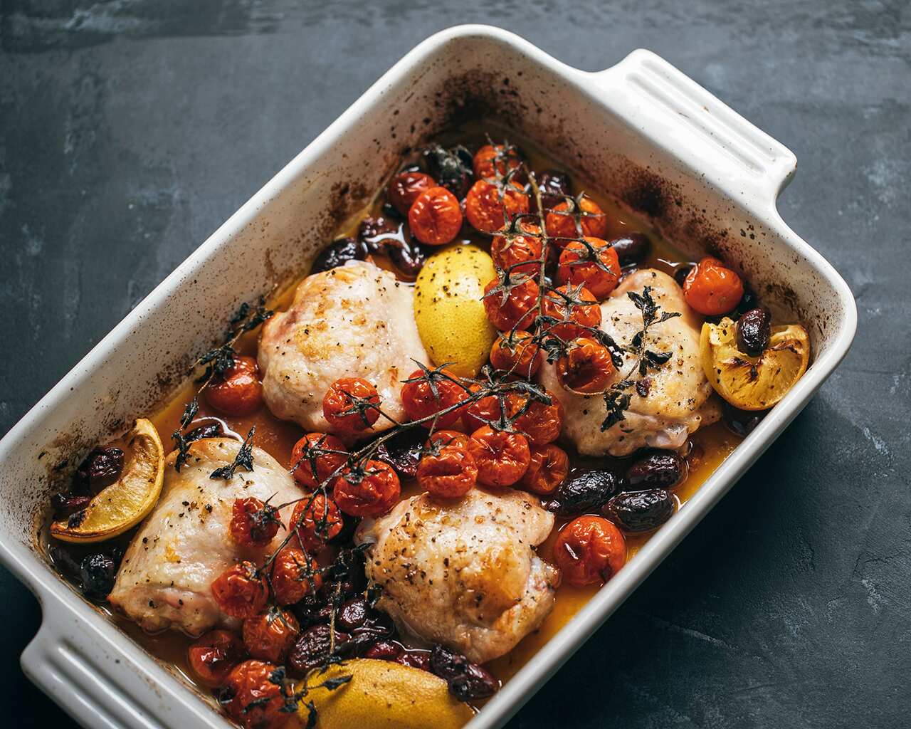 Oven-baked chicken thighs with olive, tomato and lemon