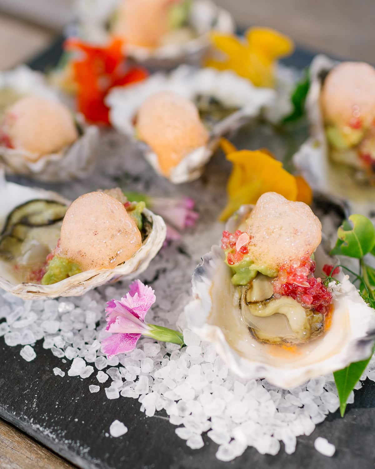 Oysters with finger lime, carrot foam and avocado cream