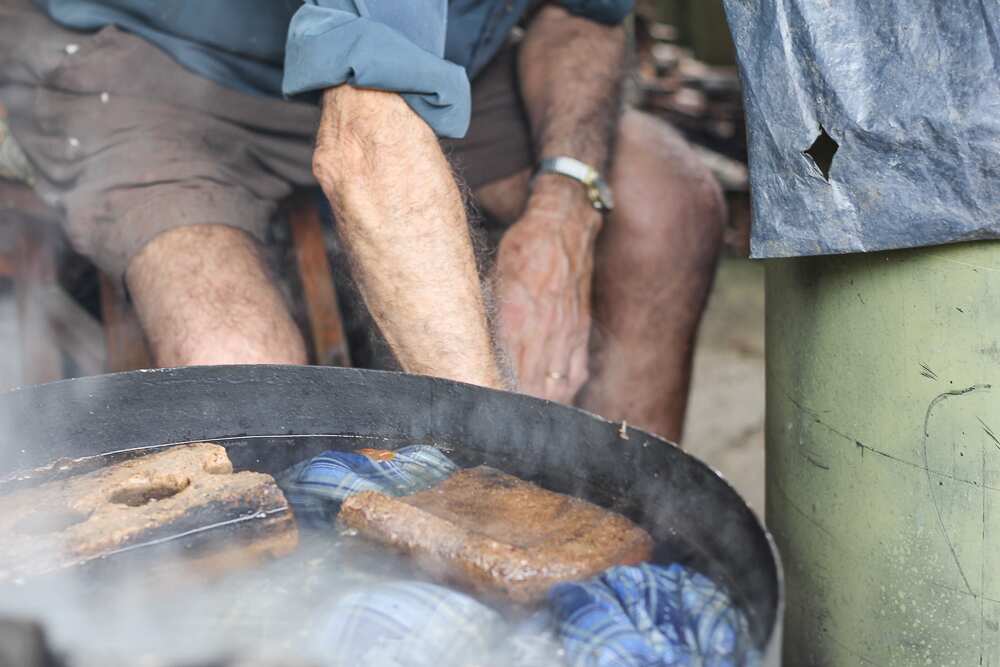 Nonno tends the fire while the passata jars sterilise