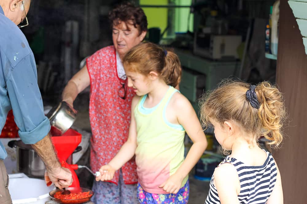 Arabella and Lottie learning how to work the tomato press.