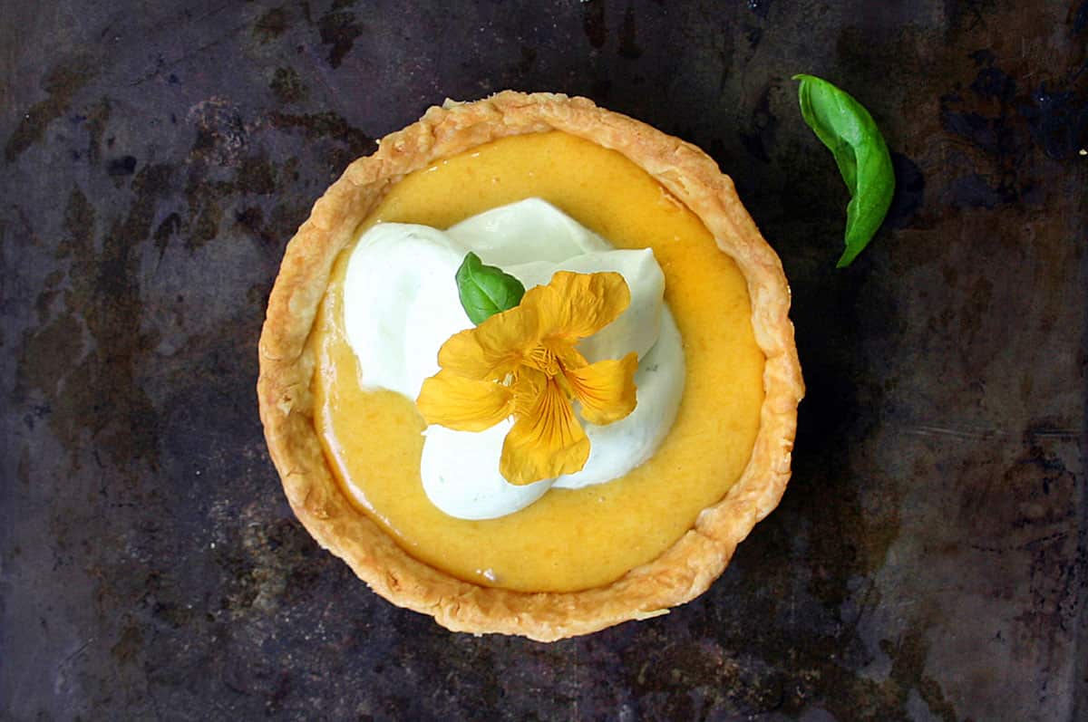 Peach curd and rosewater tartlets with basil whipped cream and nasturtium flowers 