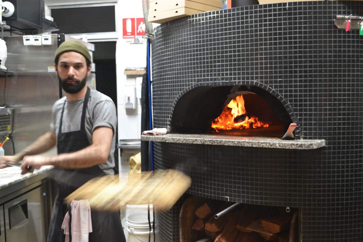 Sourdough pizza using Australian produce is cranked out of a woodfire oven at Pizza Madre.