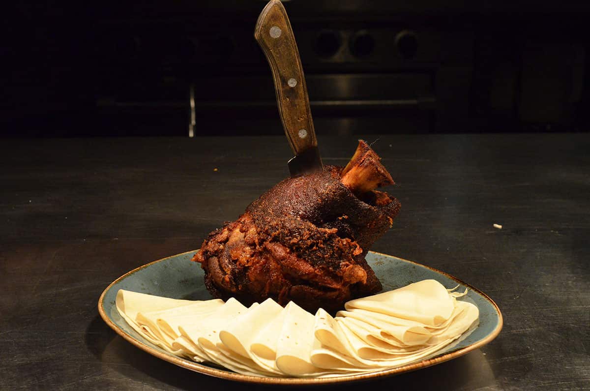 The pork hock is marinated, slow-cooked then flash-fried and served with an apple and kimchi salad, pancakes and hoi sin