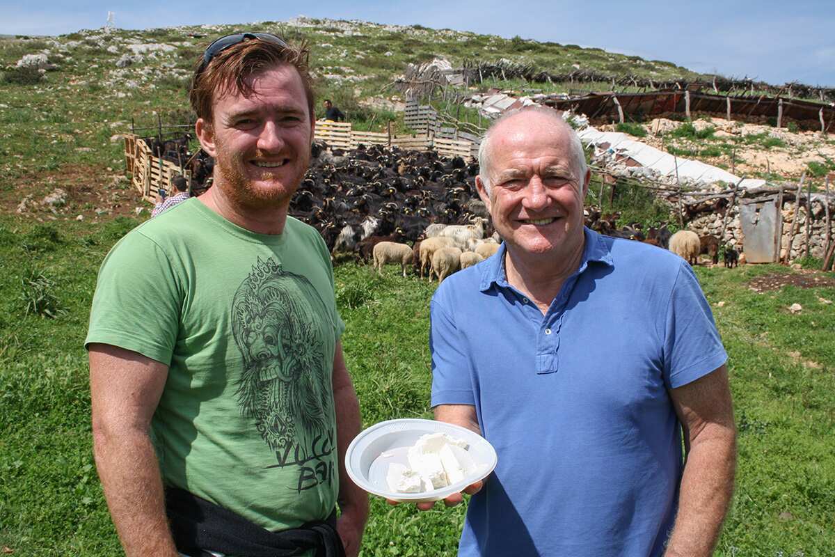  Rick and Jack Stein sample fresh goat cheese in mountains above Vlore, Albania 