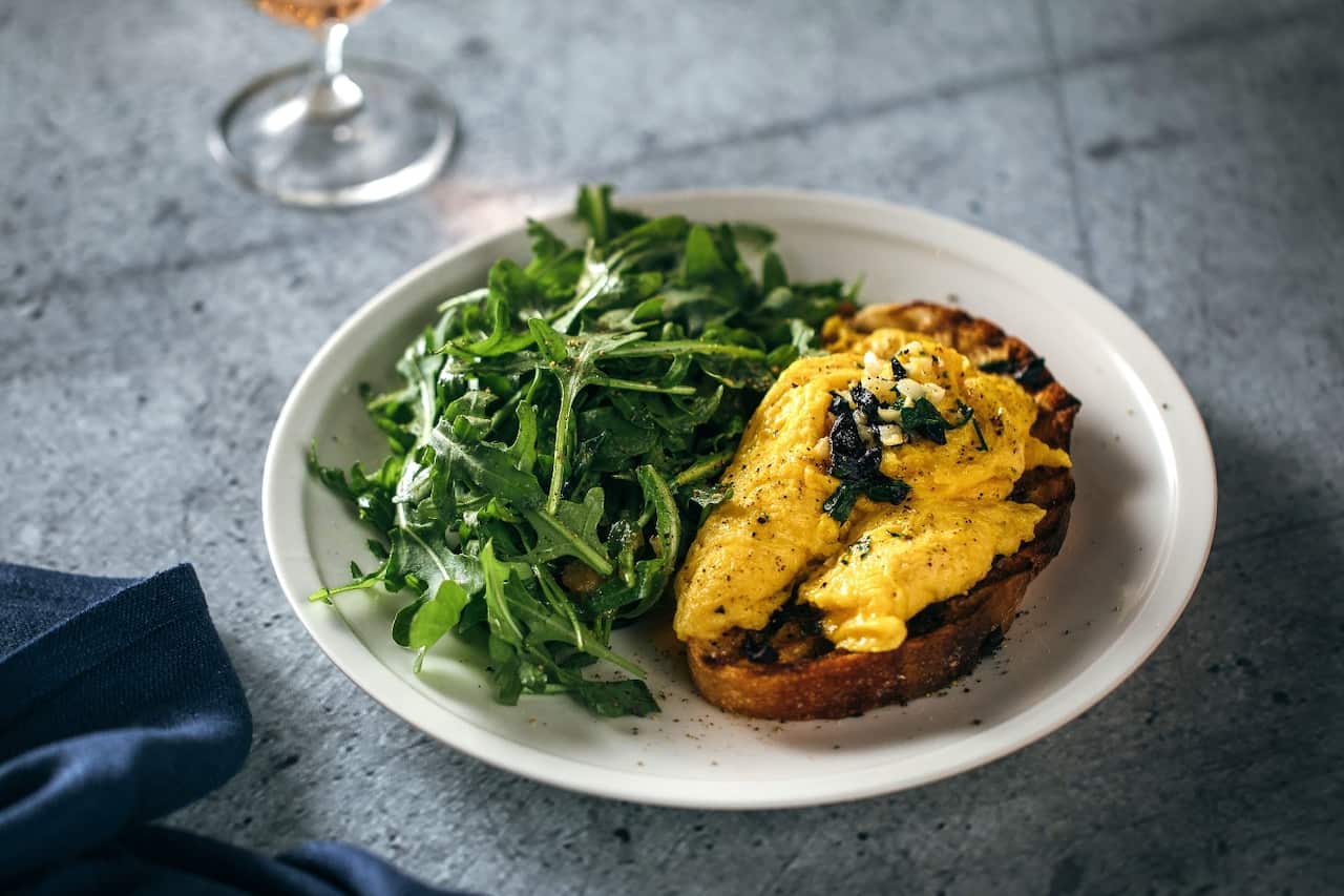 Scrambled eggs on black garlic bread