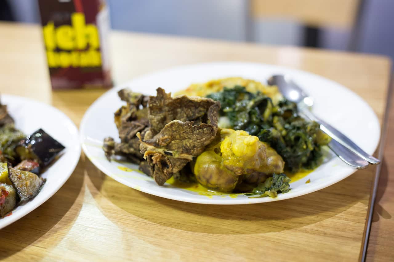  Three dishes and rice from the bain-marie menu: lamb brain, silver beet and crispy beef lung.