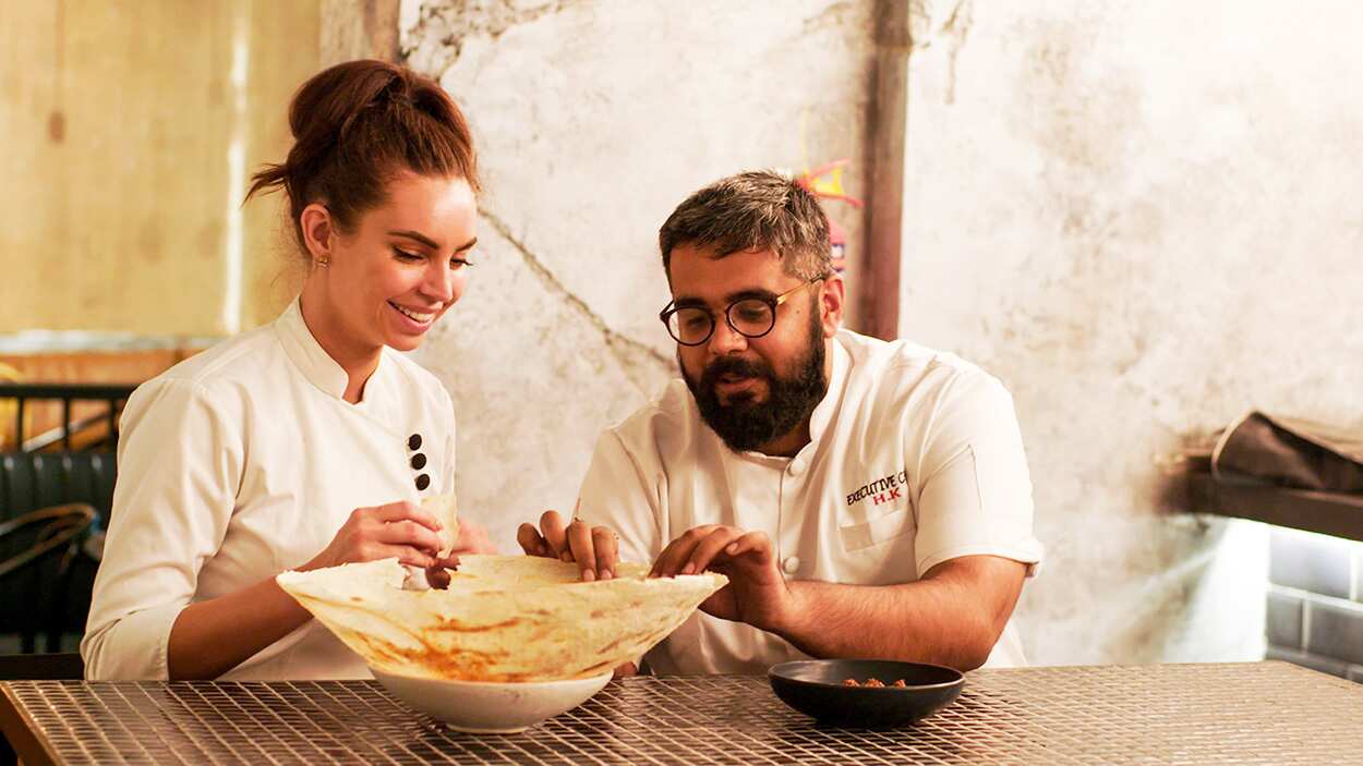 Sarah Todd and Himanil Khosla eat roti