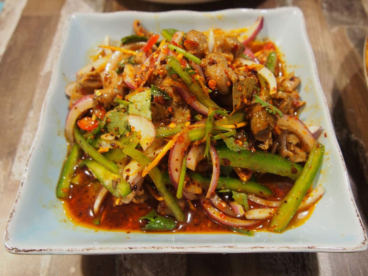 Sea snails are tossed with leafy greens in a salad.