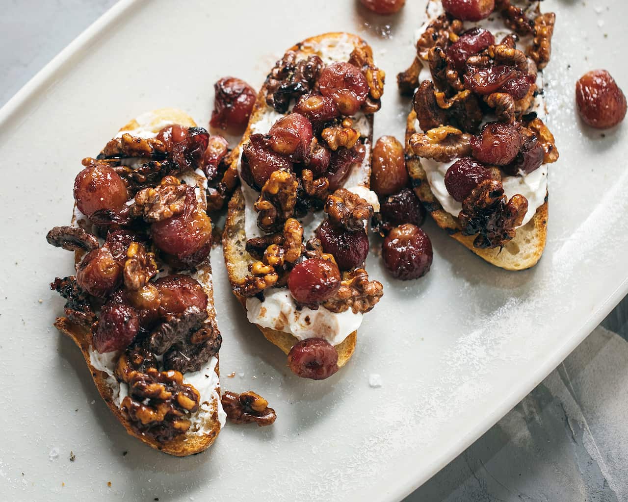 Tartines with labne, roasted red grapes and walnuts