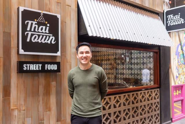 Tee stands proudly outside his ninth Thai restaurant, ready to give Thai students a taste of home.