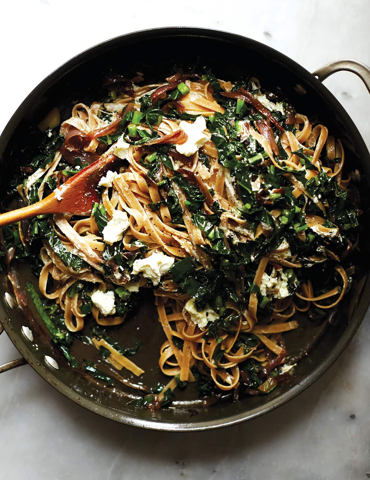 Wholewheat fettuccine with kale, caramelised onions and marinated goat’s cheese