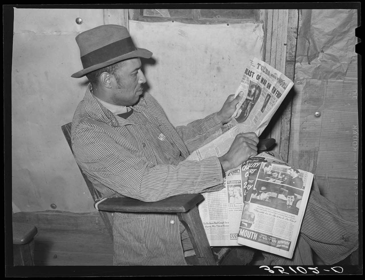 The US and the Holocaust, Pomp Hall, tenant farmer, reading newspaper to which he subscribes. Creek County, Oklahoma. See general caption number 23. February 1940.