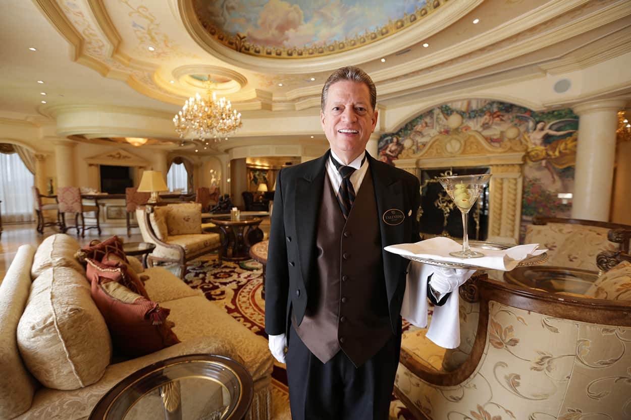 Wrold renowned butler Valentino holding a cocktail in the Verona Suite at the Westgate hotel. 