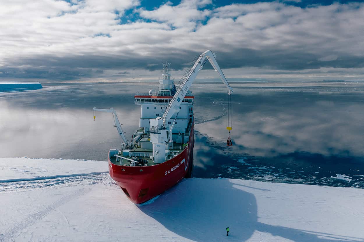 Aerial shot of the Agulhas II loading expedition members and kit from the Fimbul iceshelf before beginning its mission to find the Endurance