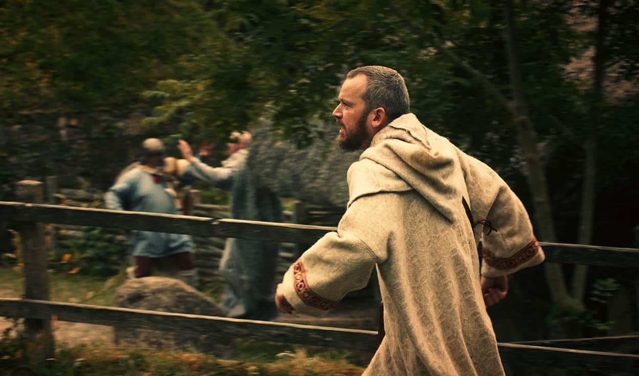 An Irish monk (played by re-enactor Pádraig Ó Ruairc) flees as Vikings attack a monastery.