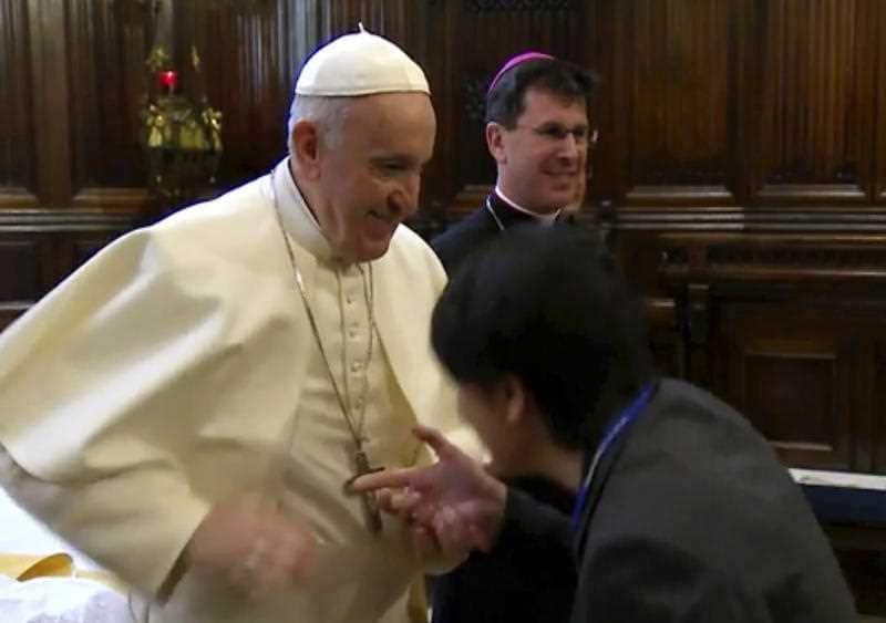 Pope Francis moves his hand as a pilgrim tries to kiss his ring, in Loreto, Italy.