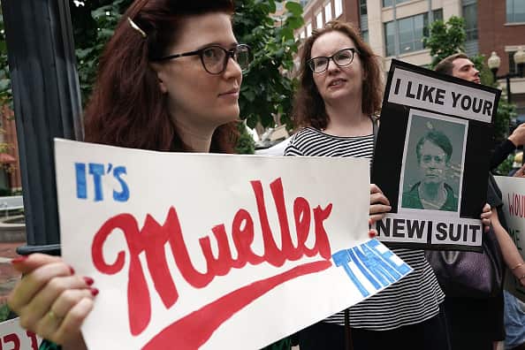 Activists hold signs outside the courthouse.