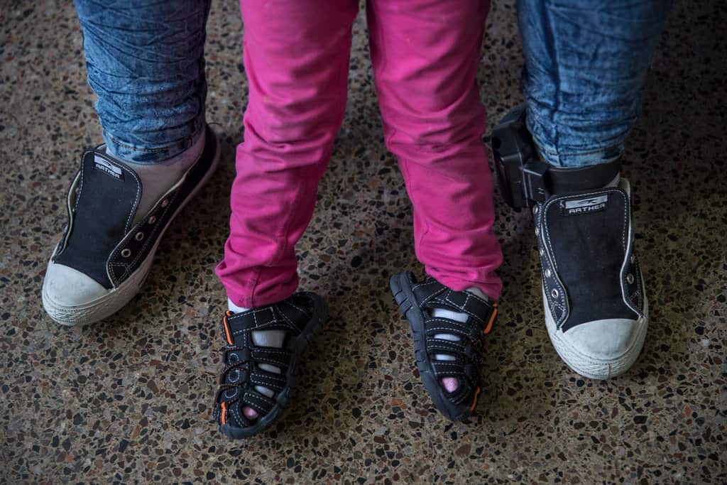 Ms. Pablo wearing an ankle monitor, with her daughter, Darly.