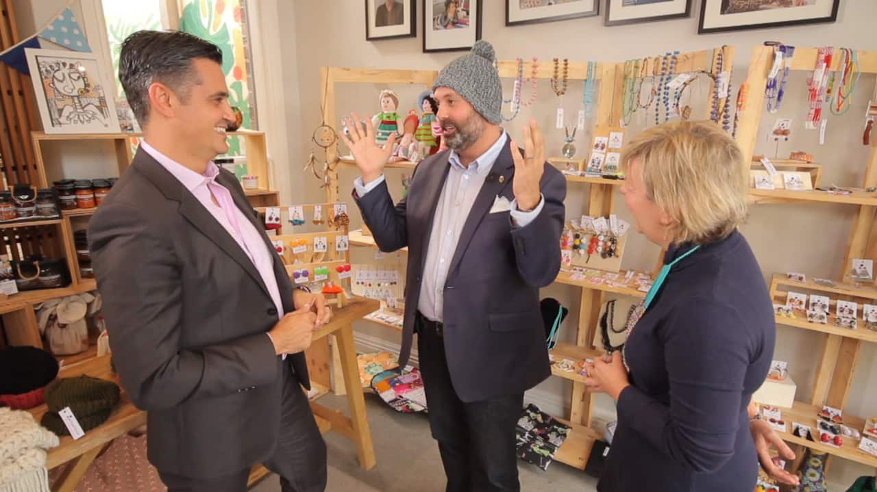 Small Business Minister Philip Dalidakis shows off a Sisterworks beanie to SBS Reporter, Ricardo Goncalves and Sisterworks CEO and Founder, Luz Restrepo 