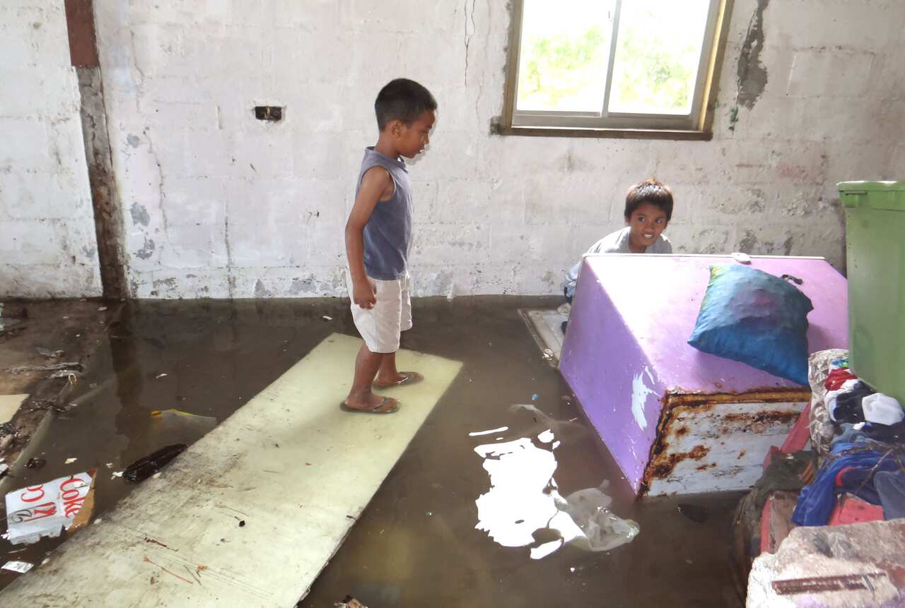 Two children look at the flooding in a house at Majuro Atoll in the Marshall Islands (AAP)
