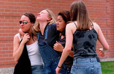 Unidentified young women head to a library near Columbine High School where students and faculty members were evacuated after the mass shooting in 1999